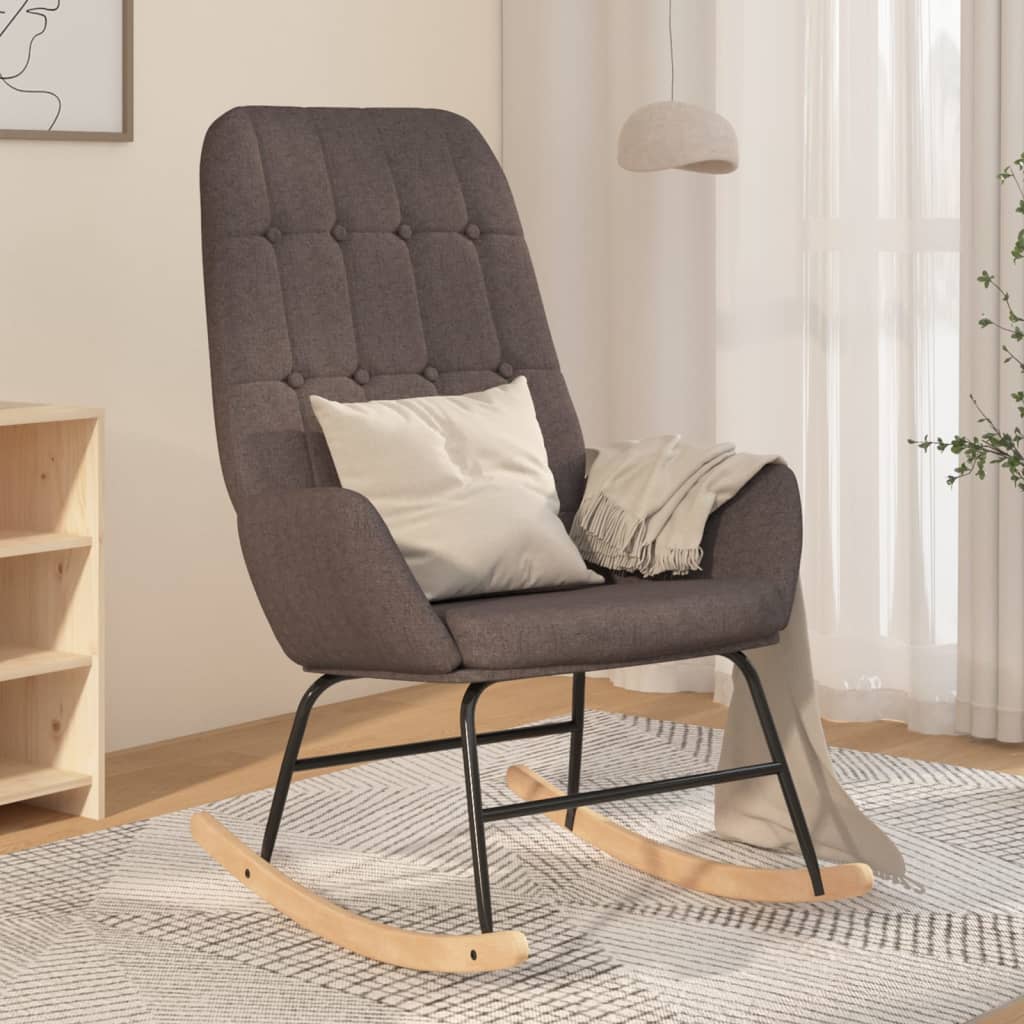 Taupekleurige schommelstoel met zachte stoffen bekleding, houten onderstel en comfortabele armleuningen
