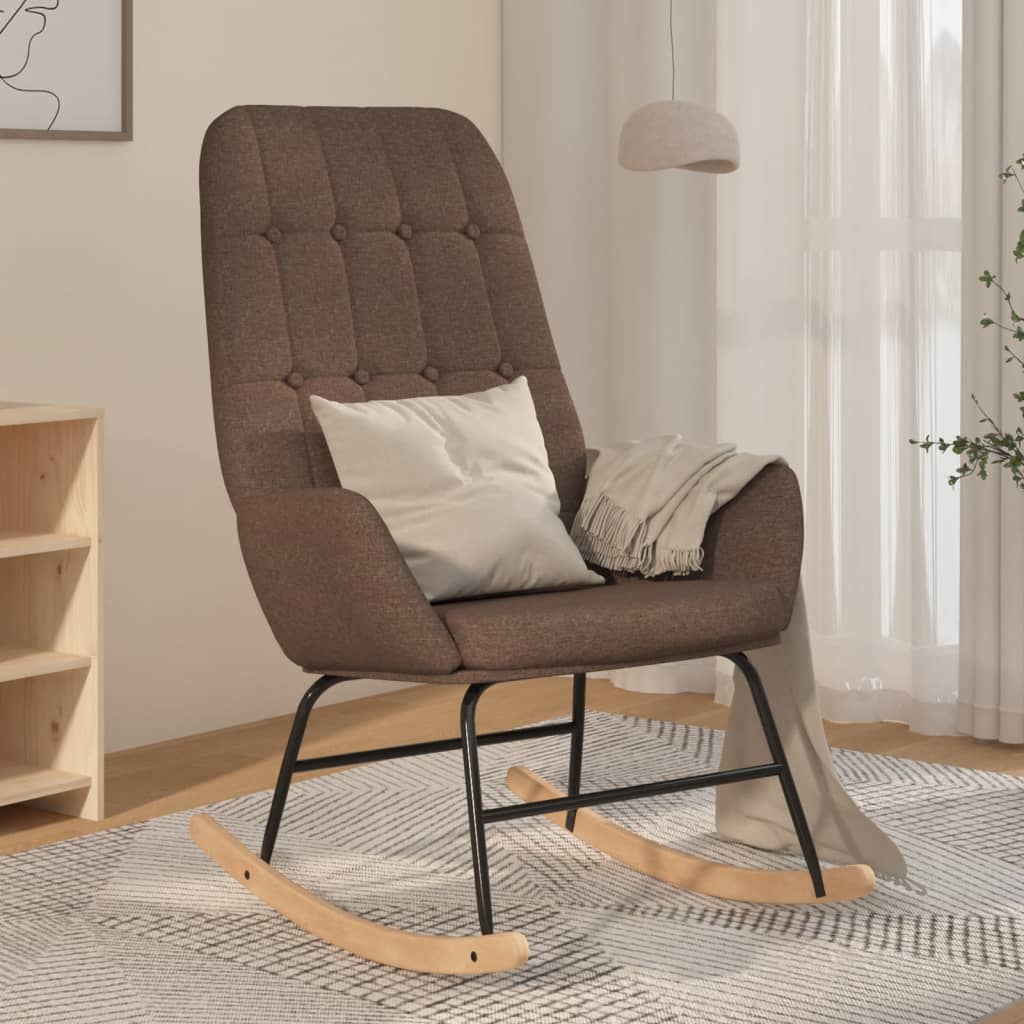 Taupekleurige schommelstoel met zachte stoffen bekleding, houten onderstel en comfortabele armleuningen